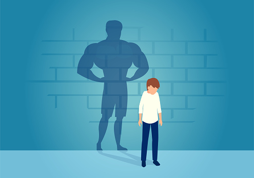Vector of a sad weak man teenager standing depressed in front of a wall with his strong shadow of himself