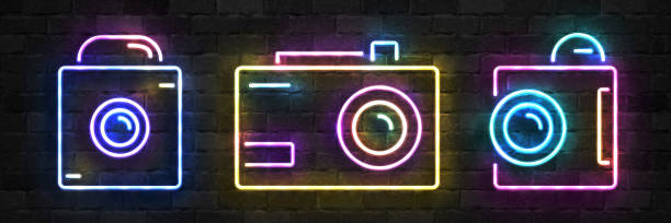 Vector set of realistic isolated neon sign of Camera symbol for template decoration on the wall background. Concept of photographer profession, cinema studio and creative process. Vector set of realistic isolated neon sign of Camera symbol for template decoration on the wall background. Concept of photographer profession, cinema studio and creative process. neon lighting photos stock illustrations