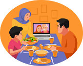 Muslim family having dinner during ramadan. Video chat with family elders. Iftar eating after fasting. Stay home covid-19 concept.