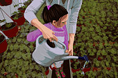 Illustration of a mother helping her daughter water the plants and learn new things about botany