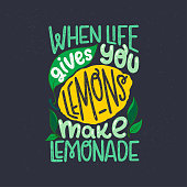 Inspiring lettering saying When Life Gives You Lemons Make Lemonade on black chalkboard. Green and yellow hand drawn inscription with citrus fruit and leaves. Sunny phrase for poster, apparel, print