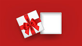 White open square gift box decorated with red ribbon tied bow on red background. Top view. Vector illustration.