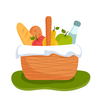 Wicker picnic basket full of healthy food on grass