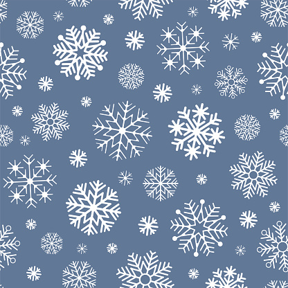 Seamless pattern with many different snowflakes on a light blue background. Cute winter wallpaper. Vector illustration.