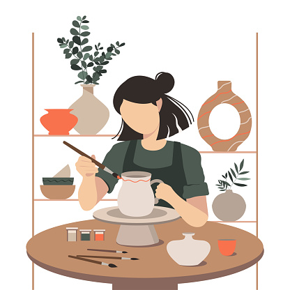 Woman decorating pot working at ceramic studio.
