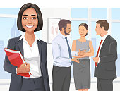 Vector illustration of a smiling young businesswoman in her office. In the background three of her coworkers are having a discussion. Concept for success, business meetings, confidence, individuality, standing out from the crowd and teamwork.