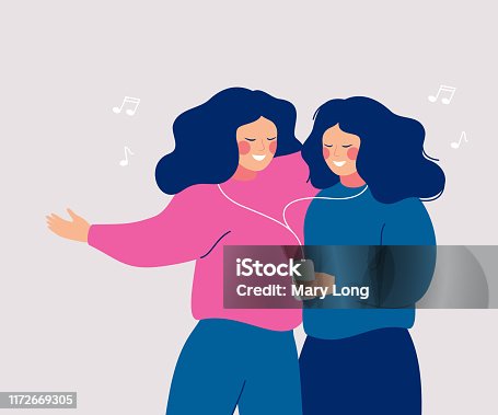 istock Young cheerful women sharing their earphone and listening to music with mobile phone and dancing. 1172669305