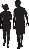 Vector silhouettes of a young couple walking together and looking at each other.
