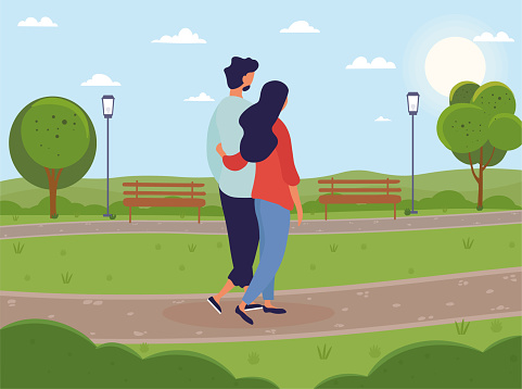 Young couple walking together in green park