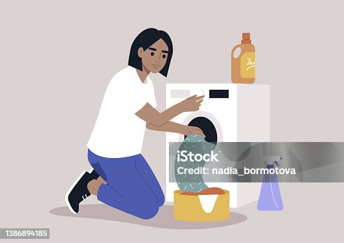 istock A young female Caucasian character loading a washing machine with a pile of laundry, domestic chores 1386894185