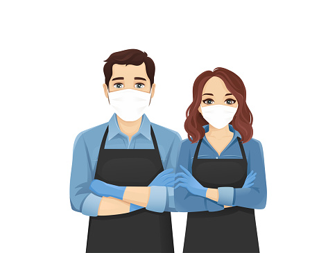 Young man and woman in aprons and protective masks