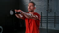 istock 4k video footage of a mature man standing alone and using a kettle bell during his workout in the gym 1335036882