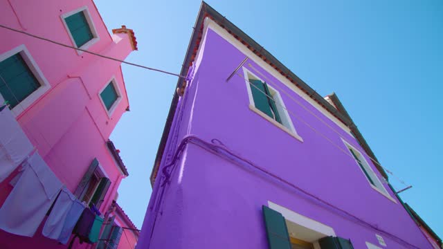 Acute corner of purple painted house at crossroad in Burano