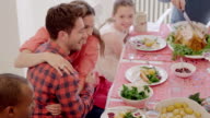 istock Affectionate couple hugging at Thanksgiving dinner table 626367108