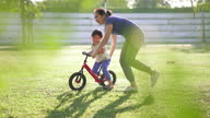 istock Asian mother teaching son to riding a bicycle in park. 1293005605