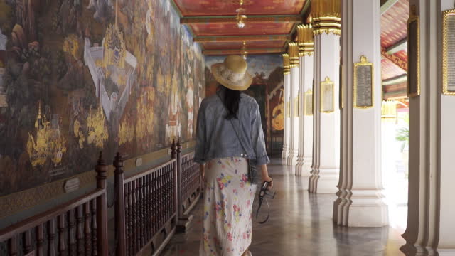 Asian tourists Women traveler enjoy travel in temple near hometown for relaxation at the Wat Phra Kaeo Bangkok Thailand. Travel destination concept.