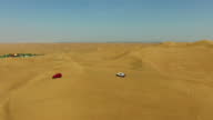 istock Beautiful Aerial Drone View of 4x4 SUV's dune bashing in Deep Desert in Arabia stock video 1389899961