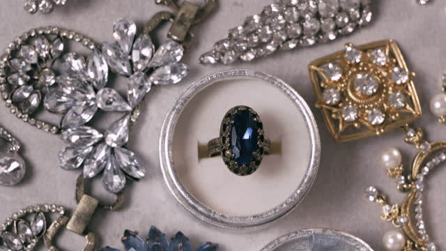 Beautiful golden ring with blue sapphire precious stone. Vintage jewelry on white background. Jewel rotating, closeup, close up, macro, studio shot