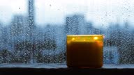 istock Burning aroma candle puts near by window that have rain drop 1331896308