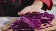 istock Chef spreading red cabbage slices he cut up on a wooden chopping board 1371897902