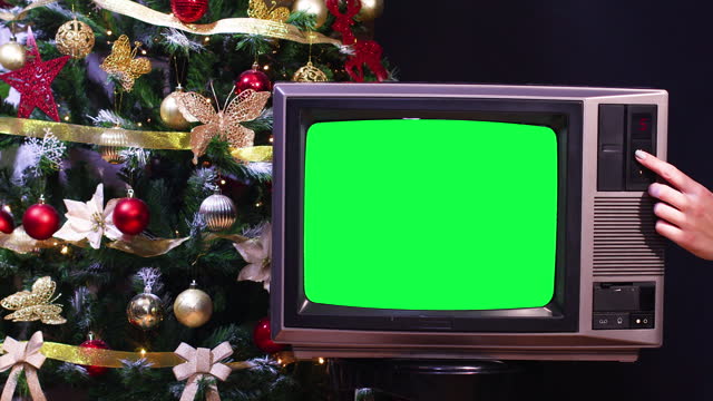 Christmas tree behind vintage old tv with green screen
