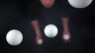 istock Circus artist wearing black juggling with white balls in slow motion 1215798377