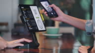 istock close up customer use mobile phone pay contactless with tablet at counter bar in cafe.small business start up.customer service concept 1192477422