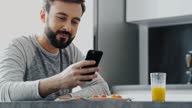 istock Close up view of Smiling bearded man having dinner and using smartphone 1351533569