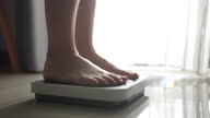 istock Close-up Foot of Woman walking on a body weighing scale 1286131941