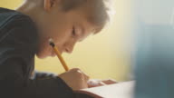 istock Close-up of boy (10-11) doing homework at desk 825086794