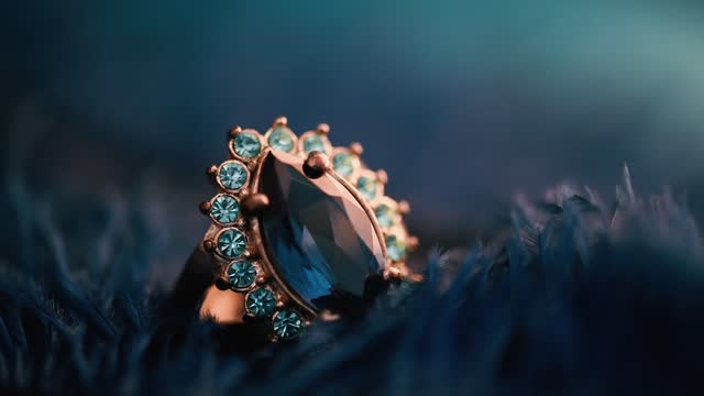 Closeup of luxury wedding ring in dark blue feather background.