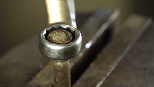 Close-up of the worker's hand tightening the nut.