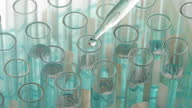istock Closeup shot of scientist dripping liquid into test tube. 1366363600