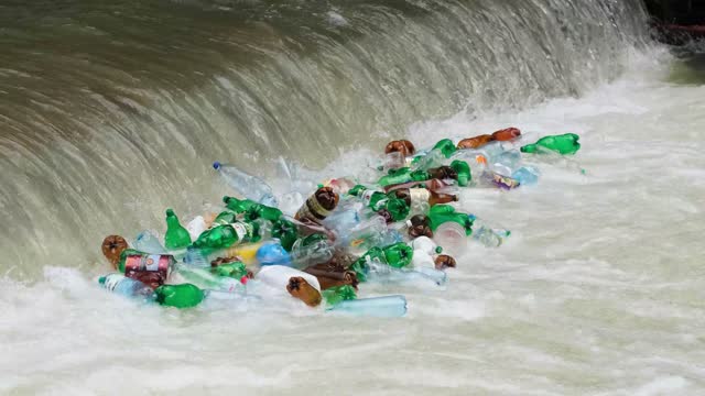 Contaminated mountain river with plastic debris and toxic debris.