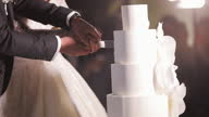 istock Cut the wedding cake. The bride and groom cut the wedding cake. Detail of wedding cake cutting by newlyweds 1323352123