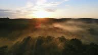 istock Fabulous sunset from a bird's eye view. Fog illuminated by the sun. Flight over the forest that is covered with fog at sunset 1332671435