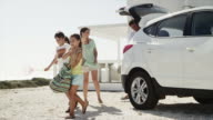 istock Family unpacking car and walking toward beach 503131121