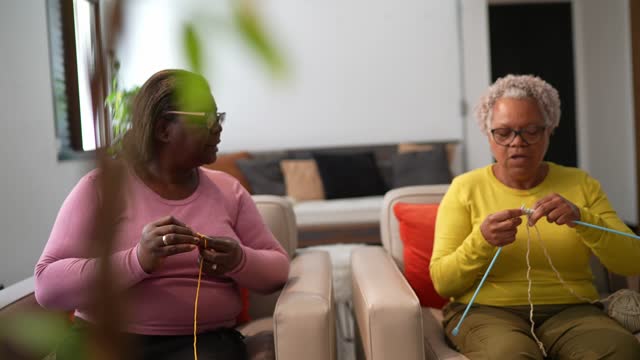 Group of senior friends women knitting at home