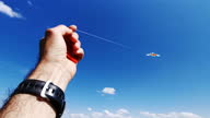 istock Hand flying kite in clear blue sky, point of view. Childhood fun. 1324759617