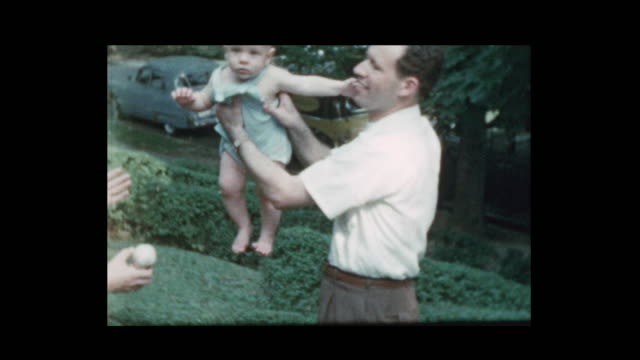 Happy 50's Mom and Dad toss baby