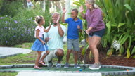 istock Interracial family, two children playing miniature golf 1307087378