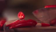 istock Knife Cutting Red Chilli Pepper on Wood in Slow Motion 1368142118