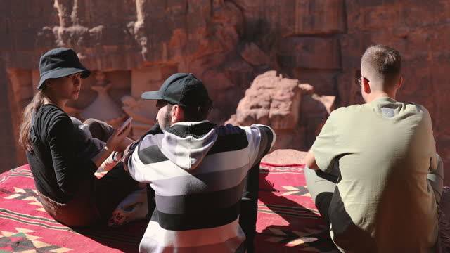 Males and female explorers contemplating the ancient world of Petra