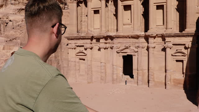 Man explorer contemplating the ancient world of Petra