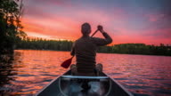 istock Man paddling a canoe at sunset - POV 857888042