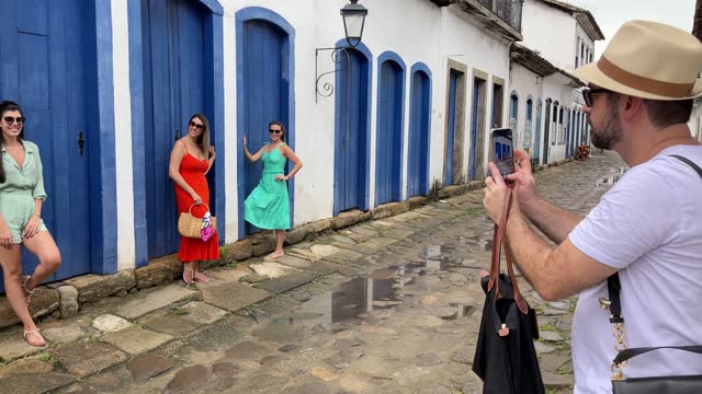 Man taking pictures of friends in front of antique house in Paraty old town