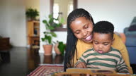 istock Mom reading to her little boy while sitting in their living room 1385078553