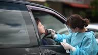istock outdoor at car park Asian chinese female doctor with PPE taking nasal swab from patient Coronavirus test. Medical worker in protective suite taking a swab for corona virus test, potentially infected woman 1315811552