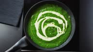 istock Pouring vegan cream into a pan with spinach puree on stove 1297469471