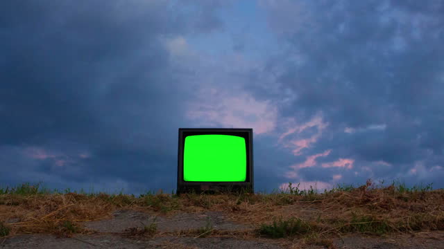Retro television with chroma key screen outside at dusk